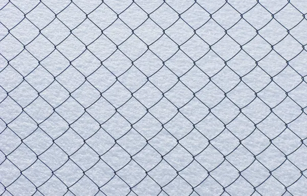 Rede de arame no fundo da neve — Fotografia de Stock