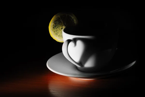 Tasse mit Zitrone in dunkel — Stockfoto