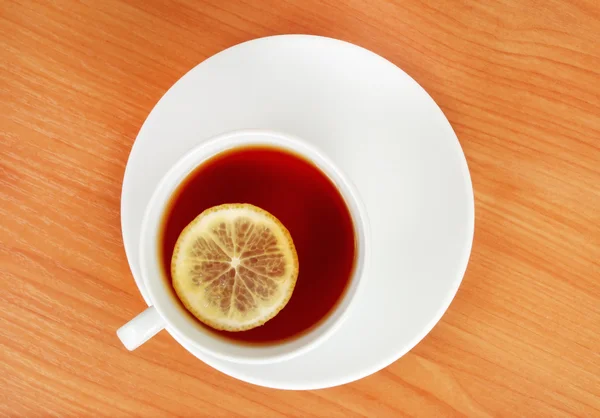 Plano superior de uma xícara de chá com limão na mesa de madeira — Fotografia de Stock