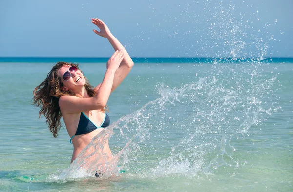 Mujer divertida salpicando en el mar — Foto de Stock