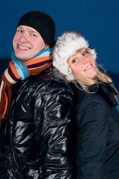 Attractive winter couple standing back-to-back — Stock Photo, Image