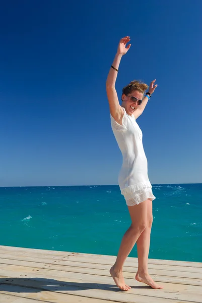 Красивая стройная женщина танцует у моря — стоковое фото