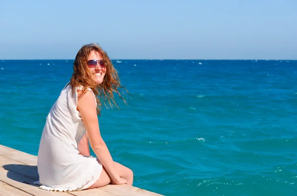 Beautful kadın iskelede oturuyordu — Stok fotoğraf