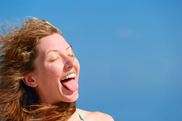 Mujer divertida muestra su lengua — Foto de Stock