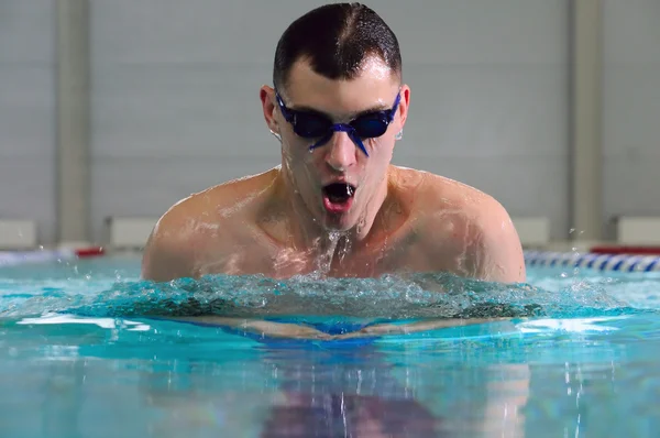 Férfi úszik a mellúszás a beltéri medencében — Stock Fotó
