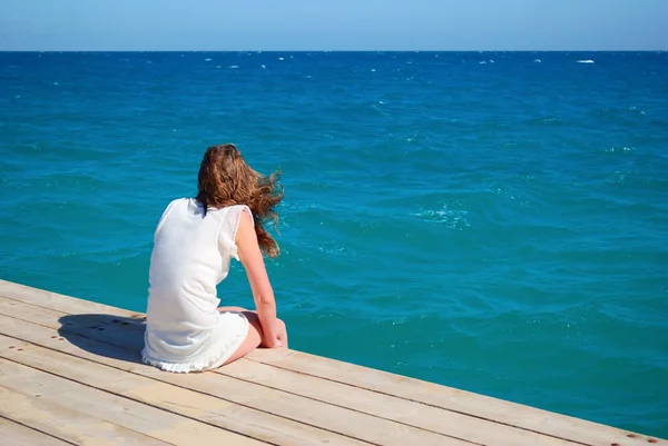 Kobieta siedzi w pobliżu morza — Zdjęcie stockowe