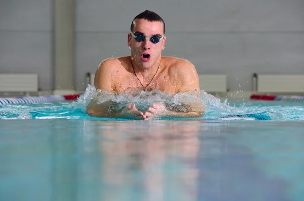 Férfi úszik a mellúszás a beltéri medencében — Stock Fotó