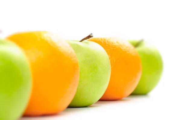 Jablka a pomeranče v řadě izolovaných na bílém — Stock fotografie