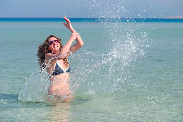 Mujer divertida salpicando en el mar — Foto de Stock