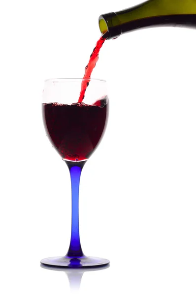 Rött vin flödar från en grön flaska till ett glas. — Stockfoto