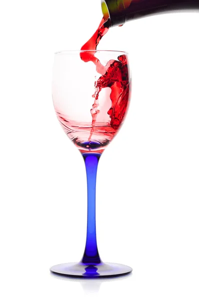 Vin rouge coulant d'une bouteille verte à un verre . — Photo