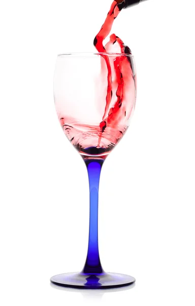 Vino rosso che scorre da una bottiglia verde a un bicchiere . — Foto Stock