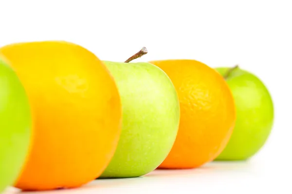 Mele e arance in fila isolate su bianco — Foto Stock
