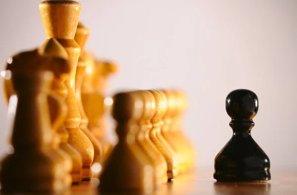 Black pawn against white chess pieces army — Stock Photo, Image