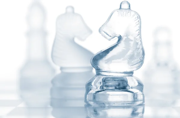 Pezzi di scacchi di vetro trasparente isolati su bianco — Foto Stock