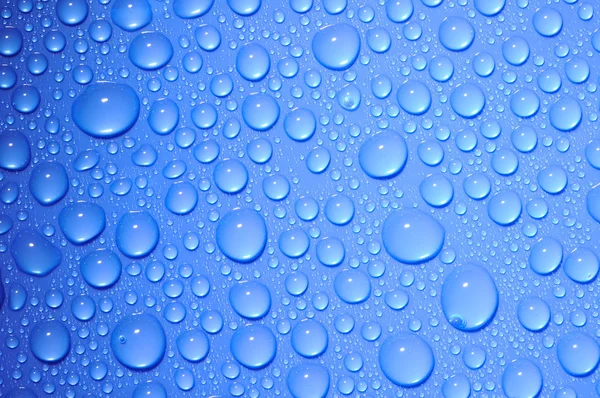 Голубые капли воды на стекло — стоковое фото