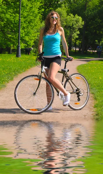 Mujer con bicicleta en el parque — Foto de Stock