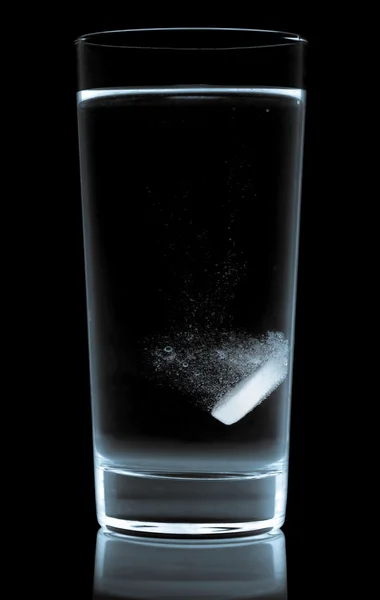 Таблетки в стакане воды изолированы на белом — стоковое фото