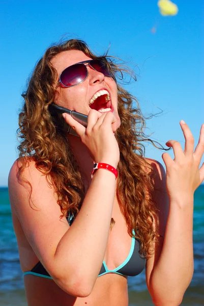 Neşeli kadın telefonu deniz kenarında konuşuyor — Stok fotoğraf