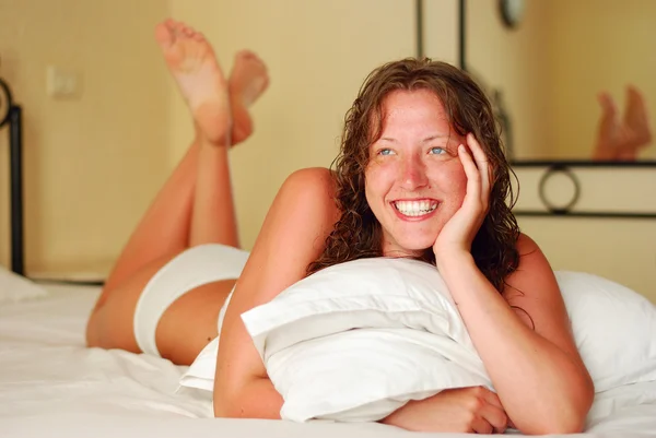 Žena se usmívá v ložnici — Stock fotografie
