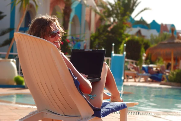Mulher em hotel tropical com laptop — Fotografia de Stock