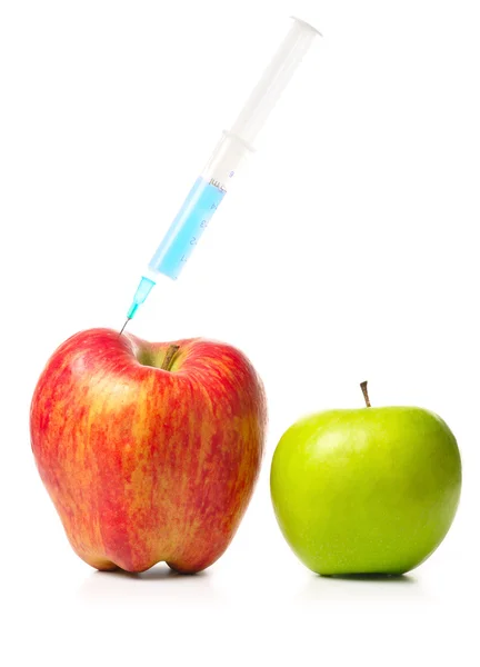 Маленькое яблоко и большое яблоко со шприцем — стоковое фото