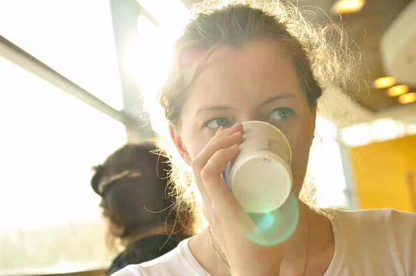 Женщина пьет из бумажной чашки — стоковое фото