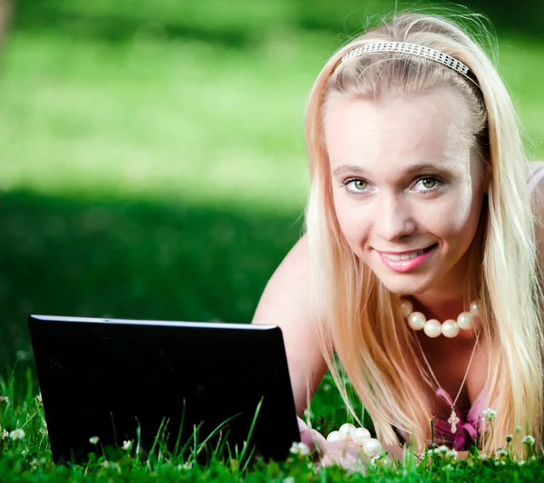 Mladá žena pomocí notebooku v parku — Stock fotografie