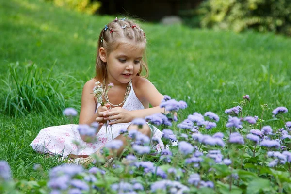 Çiçek taşıyan küçük bir kız — Stok fotoğraf