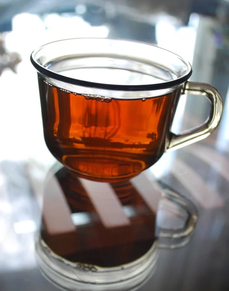 stock image A cup of tea on a glass table