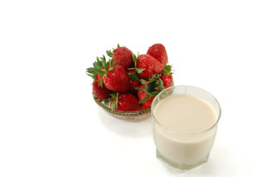 A glass of milk with ripe strawberries