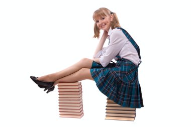 Schoolgirl is sitting on the stack of book. clipart