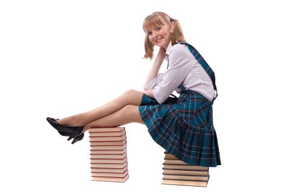 Kız öğrenci kitap yığınında oturuyor. — Stok fotoğraf