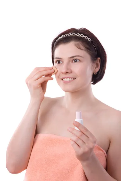 Jonge vrouw die toner crème toe te passen op gezicht — Stockfoto