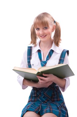 Schoolgirl is sitting on the stack of book and reading. clipart