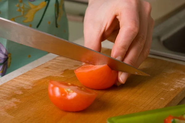 Hände des Kochs schneiden Tomaten. — Stockfoto