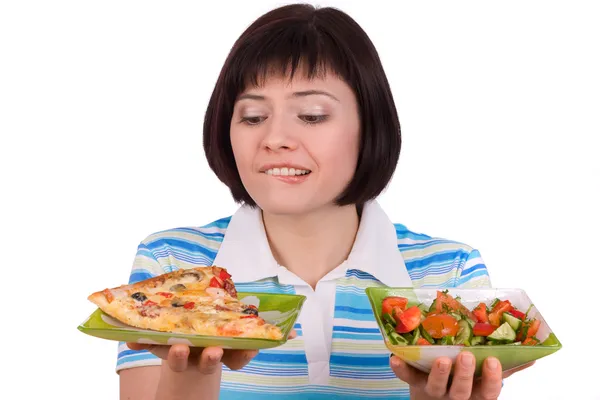 Женщина делает выбор пиццы и здорового салата — стоковое фото