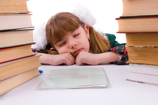 Schoolgirl is sleeping near her homework. Royalty Free Stock Images