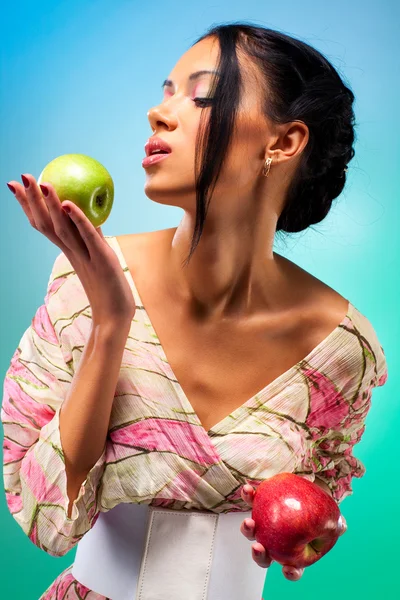 Молода жінка з двома яблуками — стокове фото