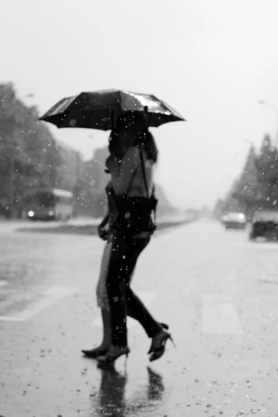 Duas mulheres caminhando sob a chuva — Fotografia de Stock