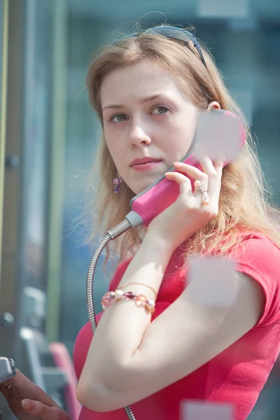 Молодая случайная женщина в телефонной будке — стоковое фото