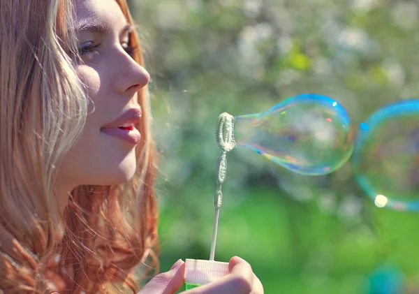 Молодая женщина с мыльными пузырями — стоковое фото