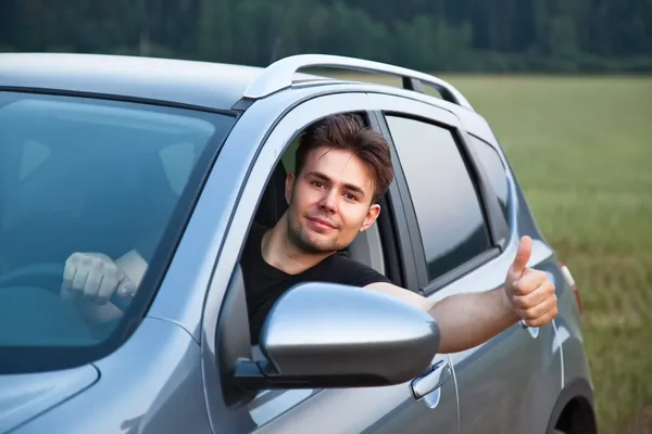 Young man looking out of car — Stock Photo, Image