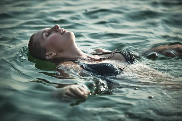 Junge Frau schwimmt — Stockfoto