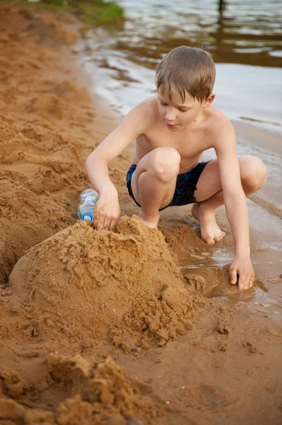 Il ragazzo costruisce sulla sabbia — Foto Stock