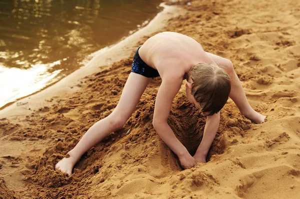 The boy builds on sand — Stock Photo, Image