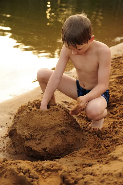 Le garçon construit sur le sable — Photo