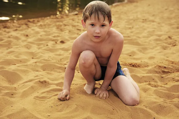De jongen bouwt voort op zand — Stockfoto