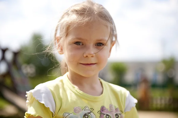 Das Mädchen spielt auf einem Kinderspielplatz — Stockfoto