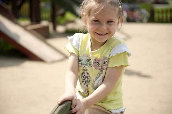 Het meisje speelt een speelplaats voor kinderen — Stockfoto